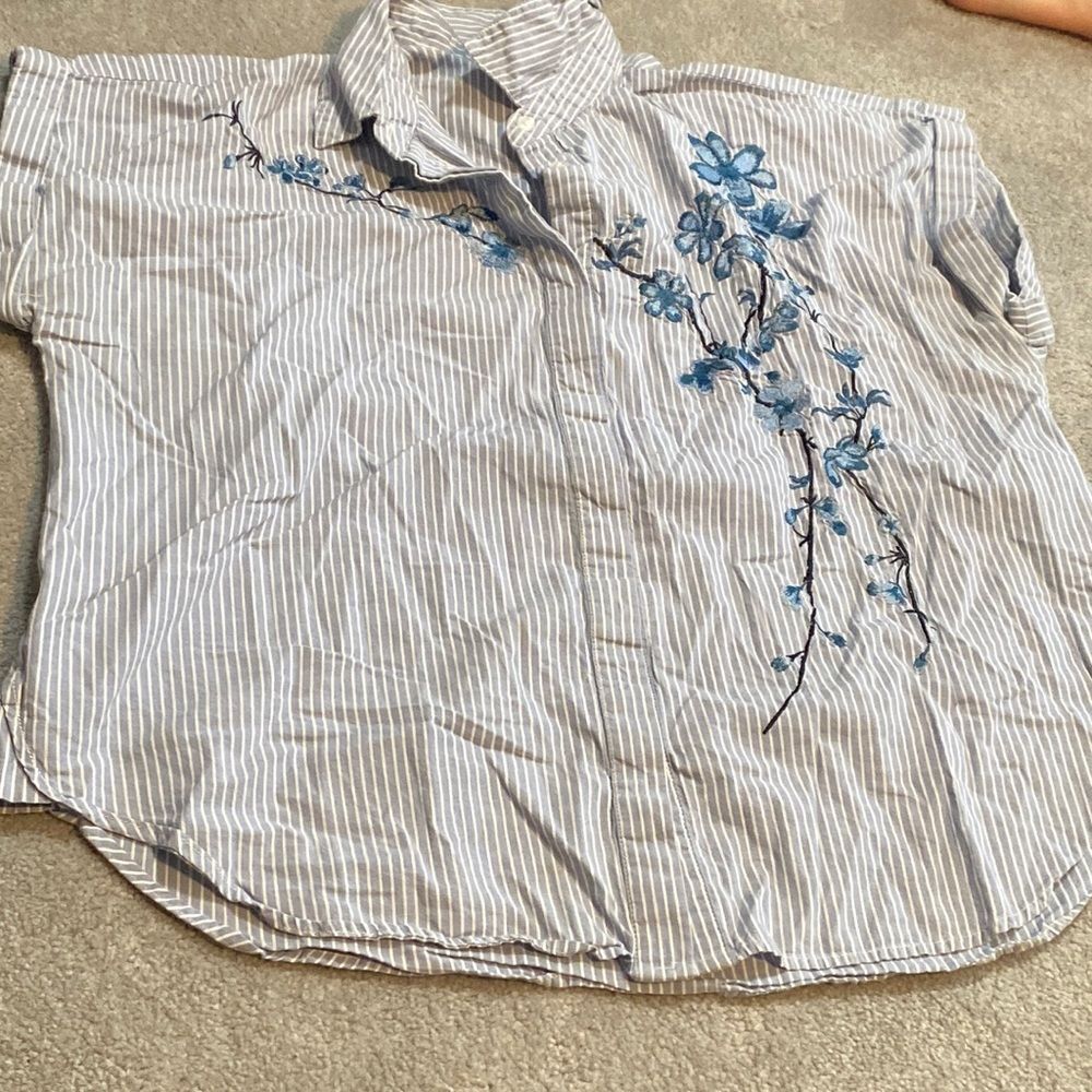 A new day blue, white pinstriped button blouse embroidered with blue flowers.